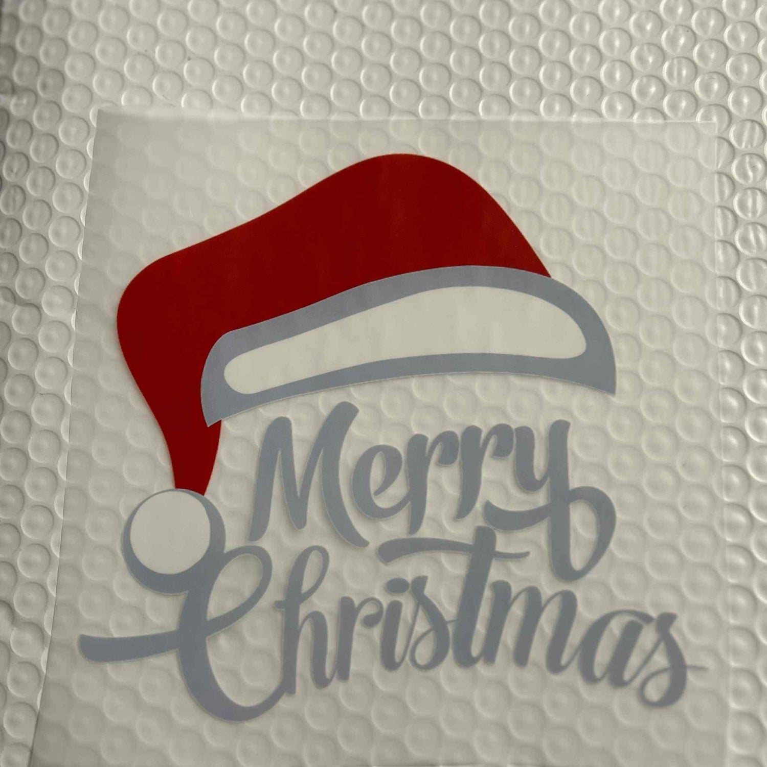 Merry Christmas holiday design with Santa hat on bubble wrap background.