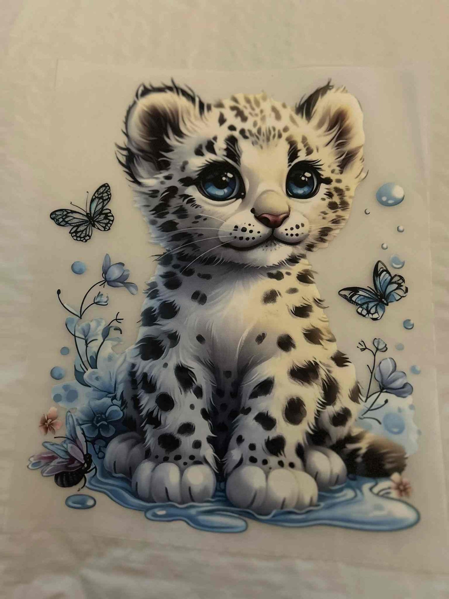 Animal design featuring a cute, spotted cub with butterflies and flowers.