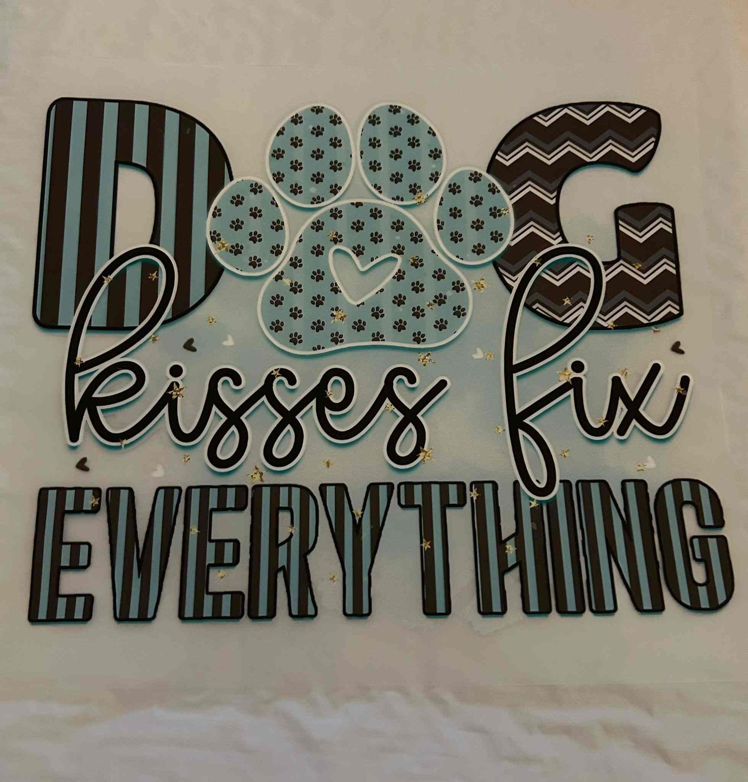 Animal design with dog paw and text &quot;Dog kisses fix everything&quot; on a decorative surface.