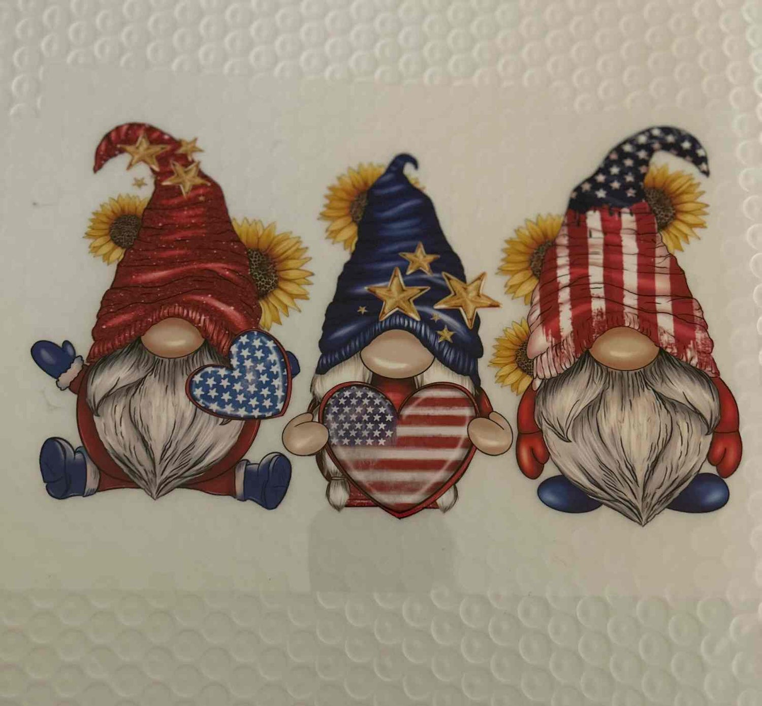 Three gnomes with patriotic hats and hearts featuring American flag designs.