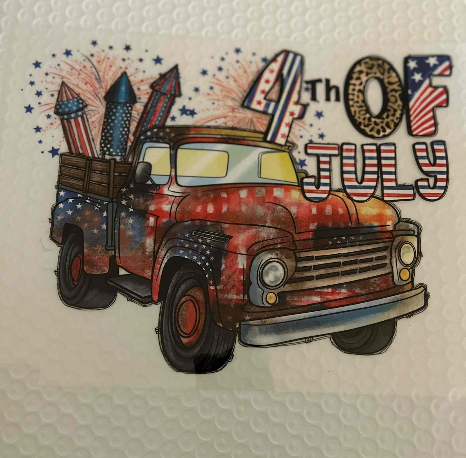 Patriotic design featuring an antique truck with American flag colors and fireworks for the 4th of July.