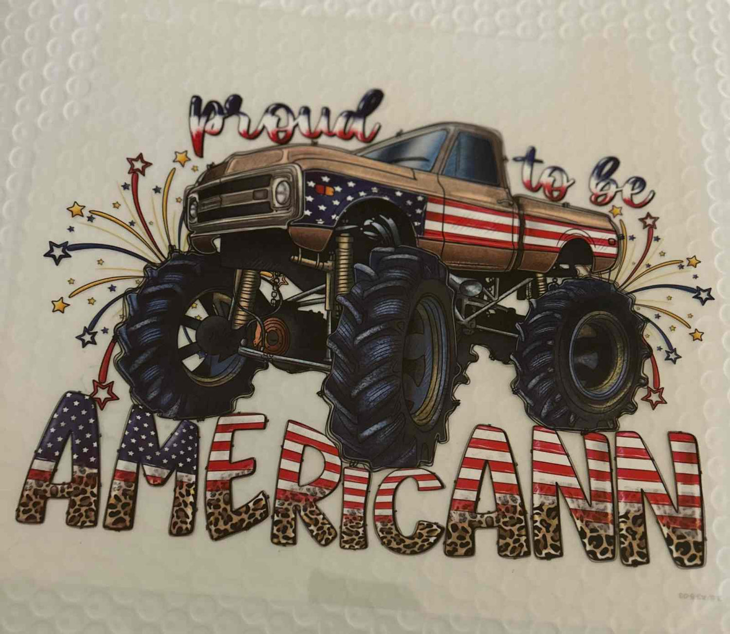 Patriotic design with an American flag-themed monster truck and &quot;Proud to be American&quot; text.