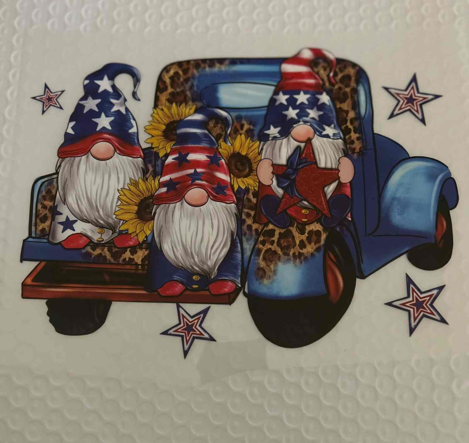 Patriotic gnomes on vintage truck with sunflowers and stars, showcasing American pride.