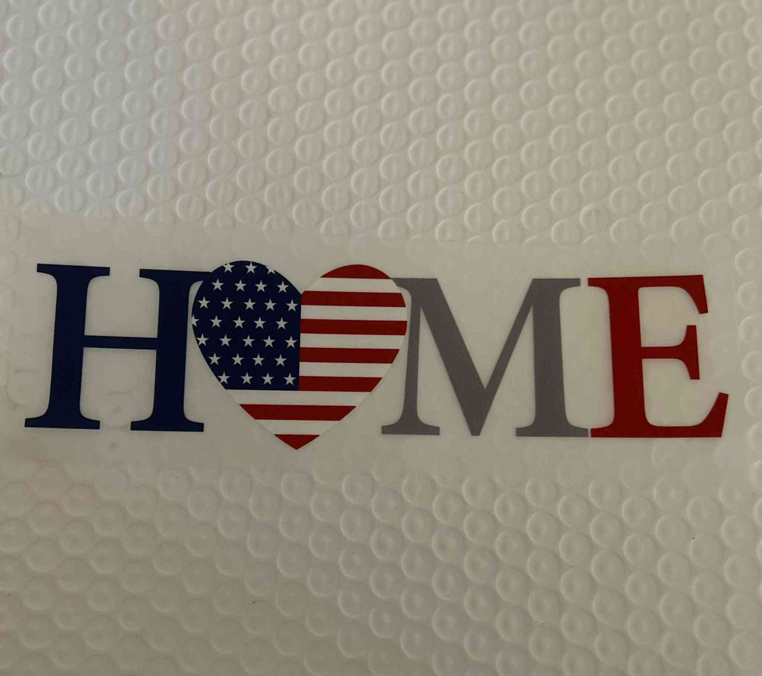 Patriotic design with &quot;HOME&quot; text featuring an American flag heart.