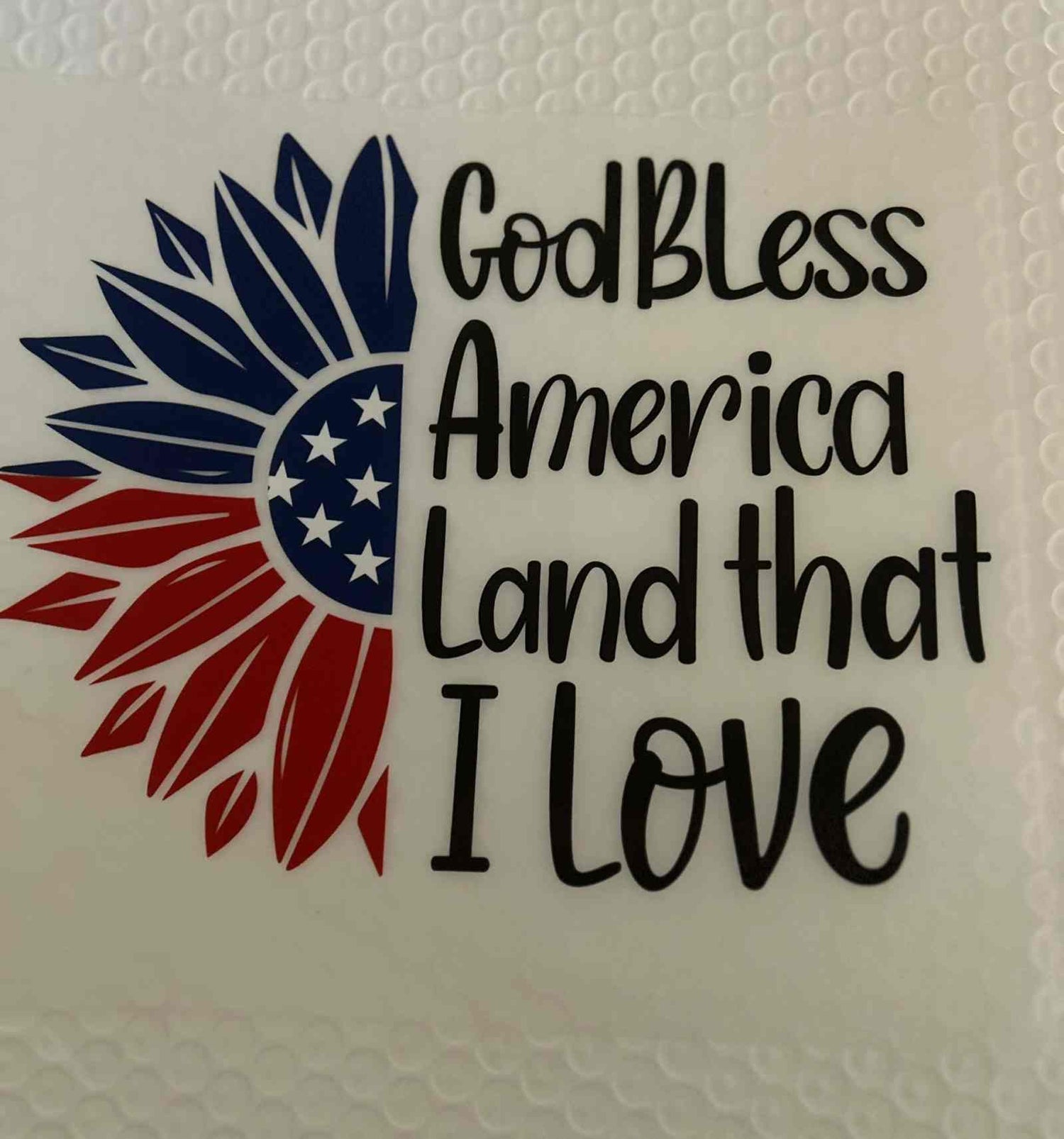 Patriotic design with &quot;God Bless America Land that I Love&quot; text and star-spangled emblem.