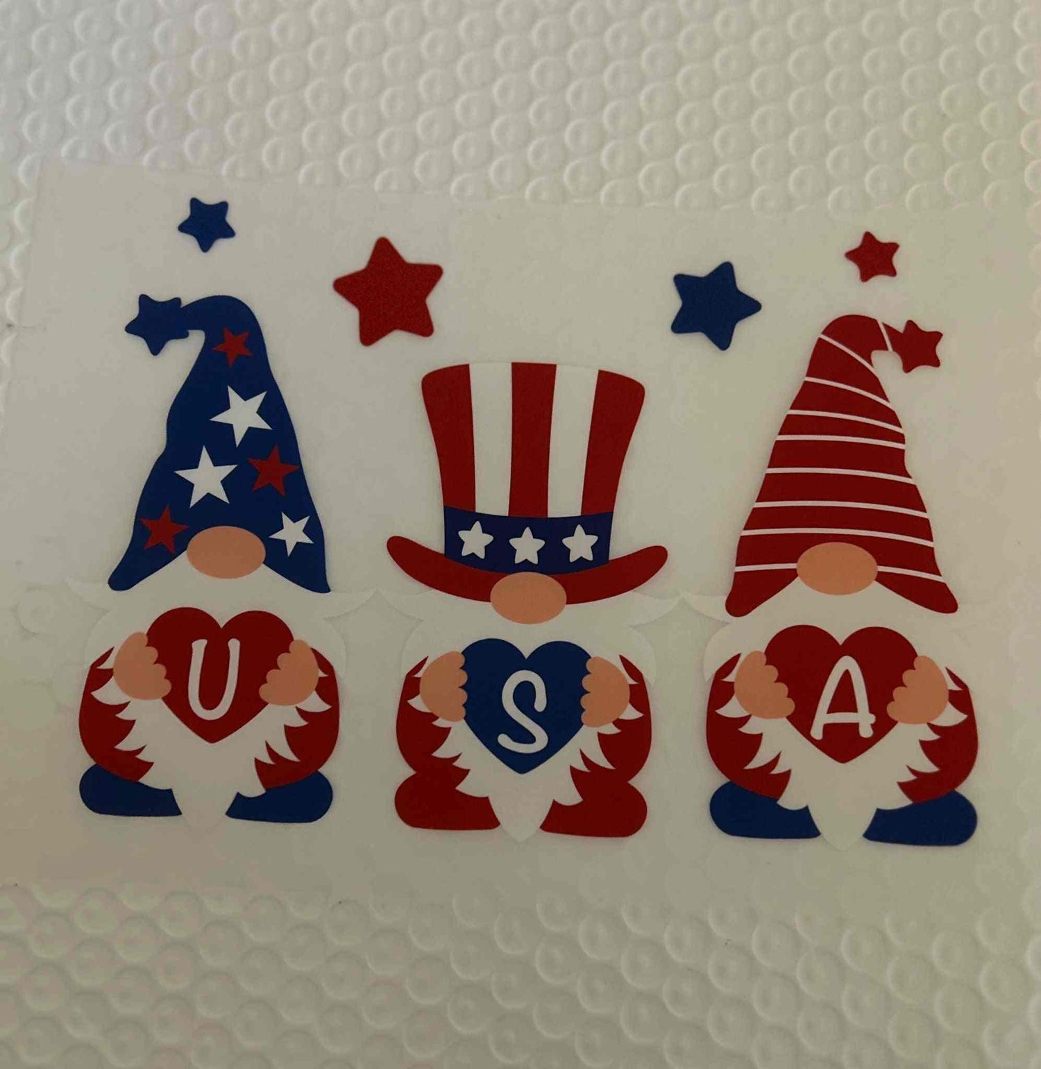 Patriotic design showing gnomes with USA letters in red, white, and blue colors.