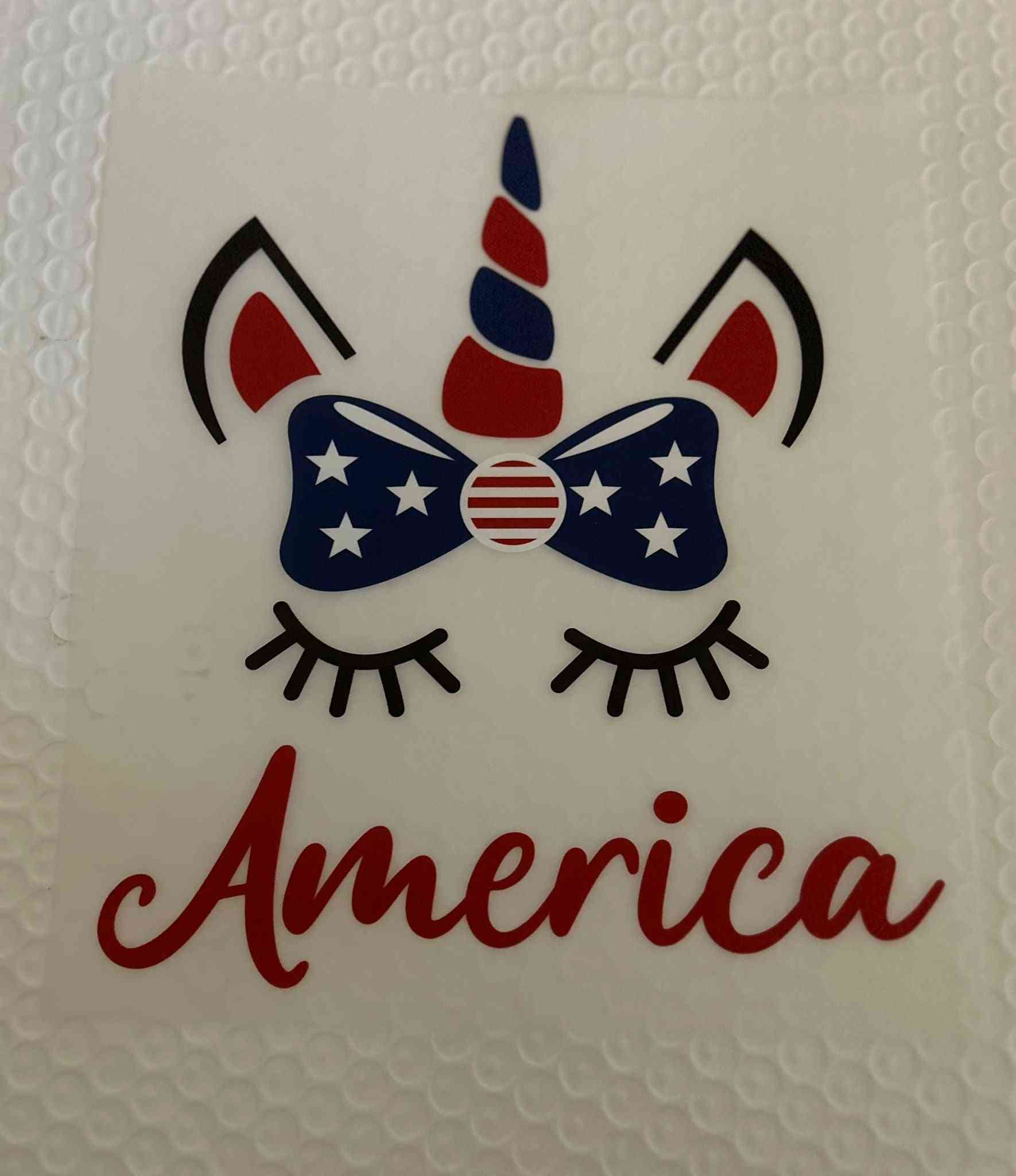 Patriotic design featuring a unicorn with American flag-themed bow and the word &quot;America&quot;.