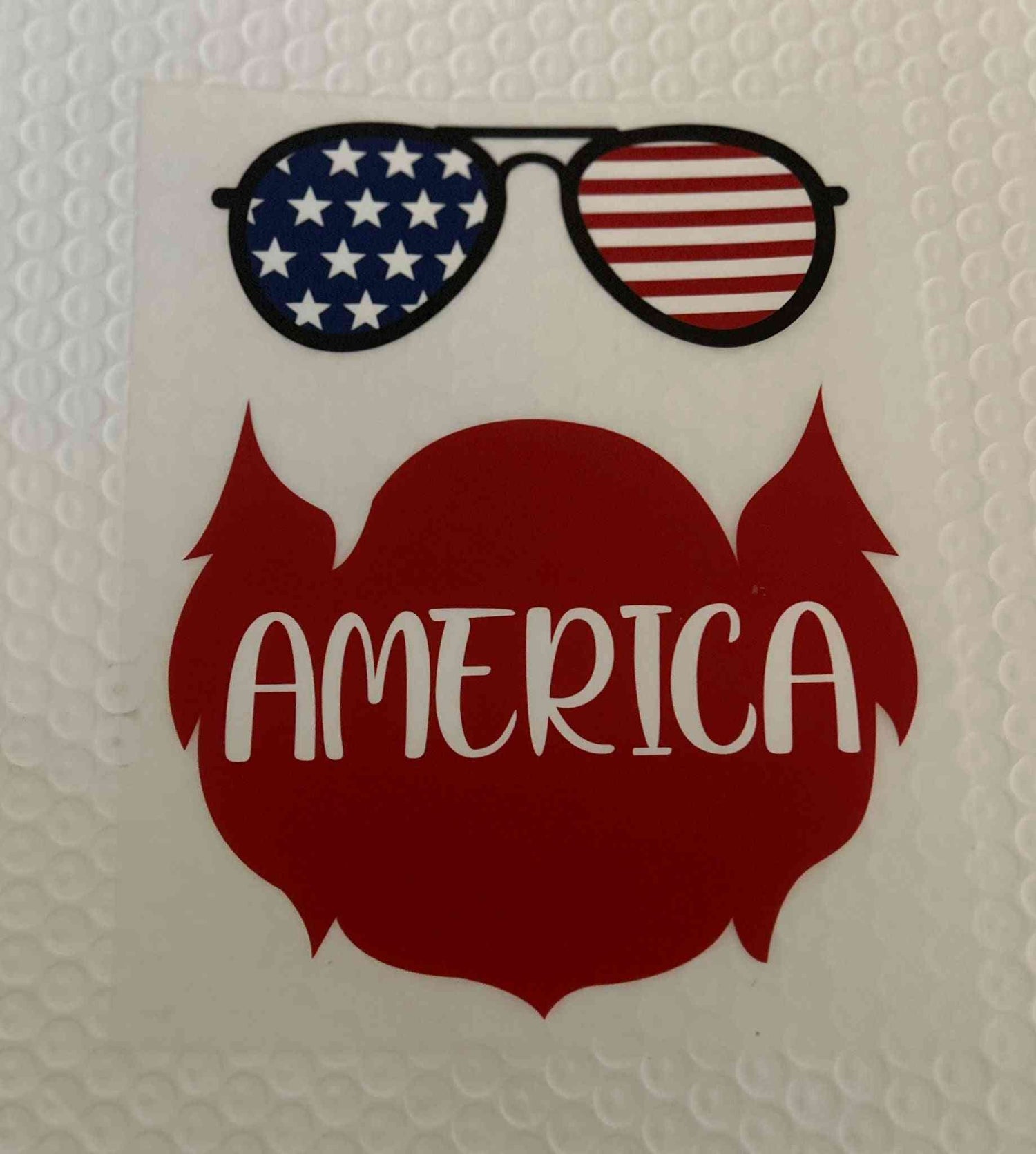 Patriotic design featuring American flag sunglasses and &quot;America&quot; text.