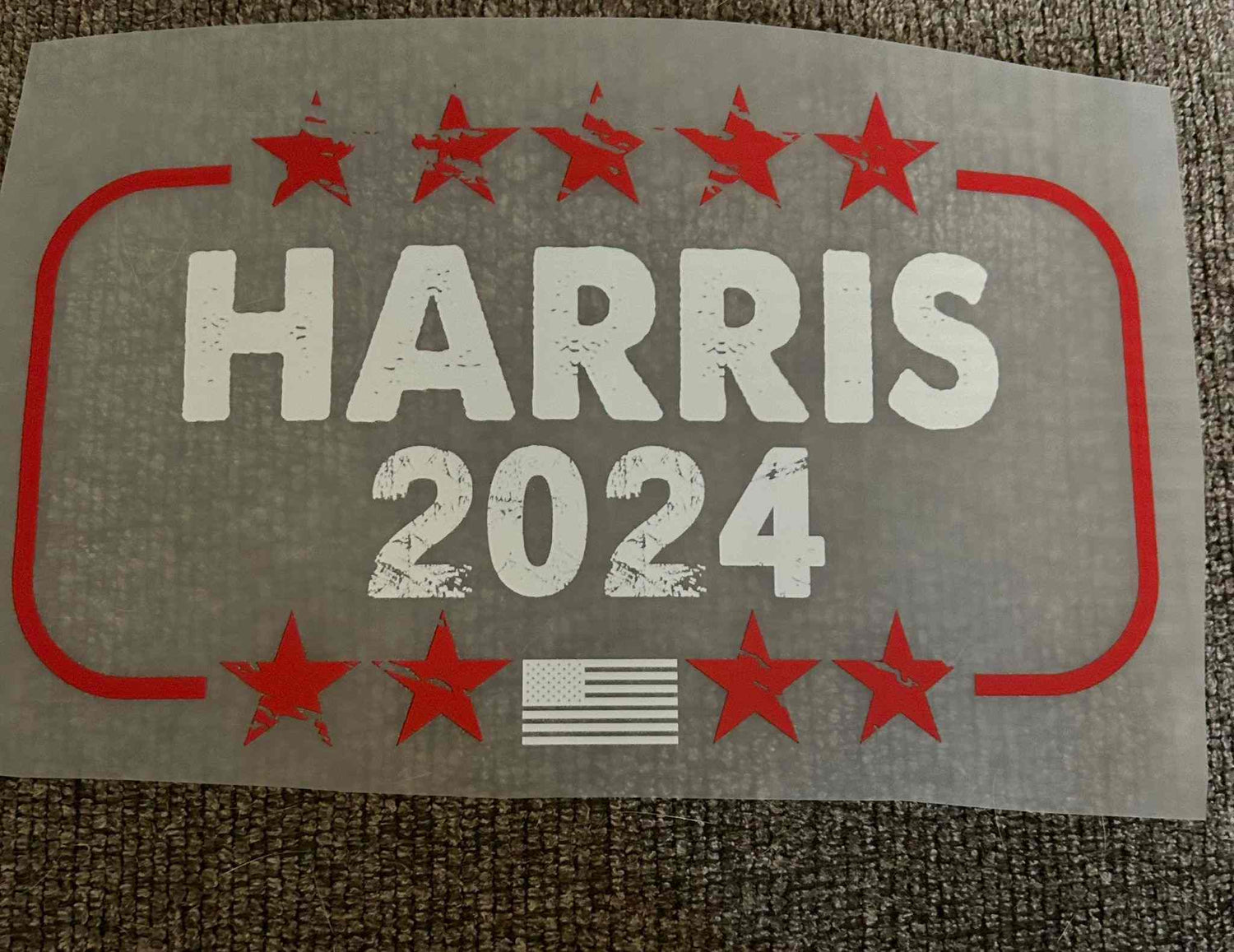 Patriotic design featuring red stars and American flag with &quot;Harris 2024&quot; text.