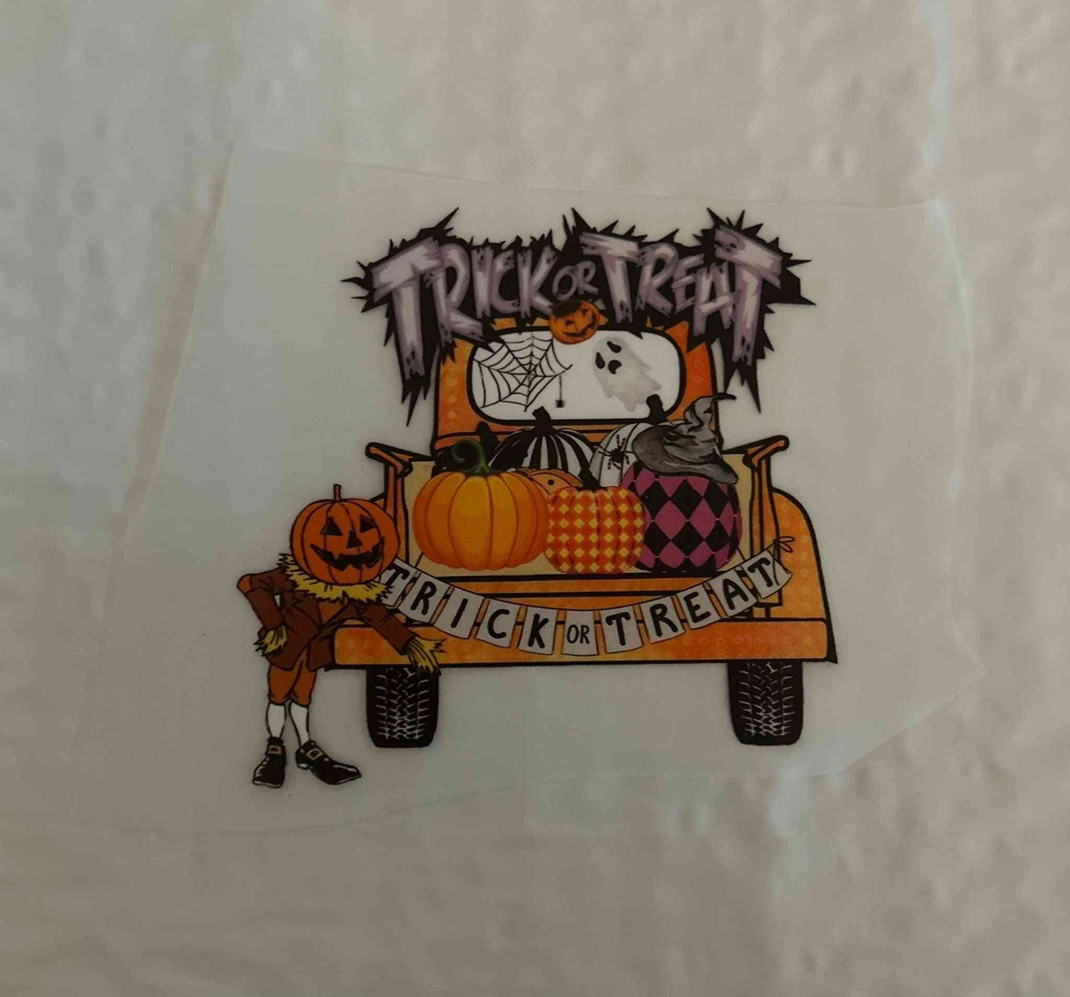 Halloween-themed design featuring &quot;Trick or Treat&quot; text on a festive truck with pumpkins and decorations.