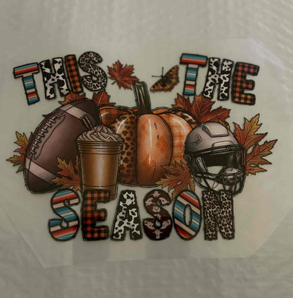 Football helmet, pumpkin, and autumn leaves with &quot;This The Season&quot; text, holiday design.