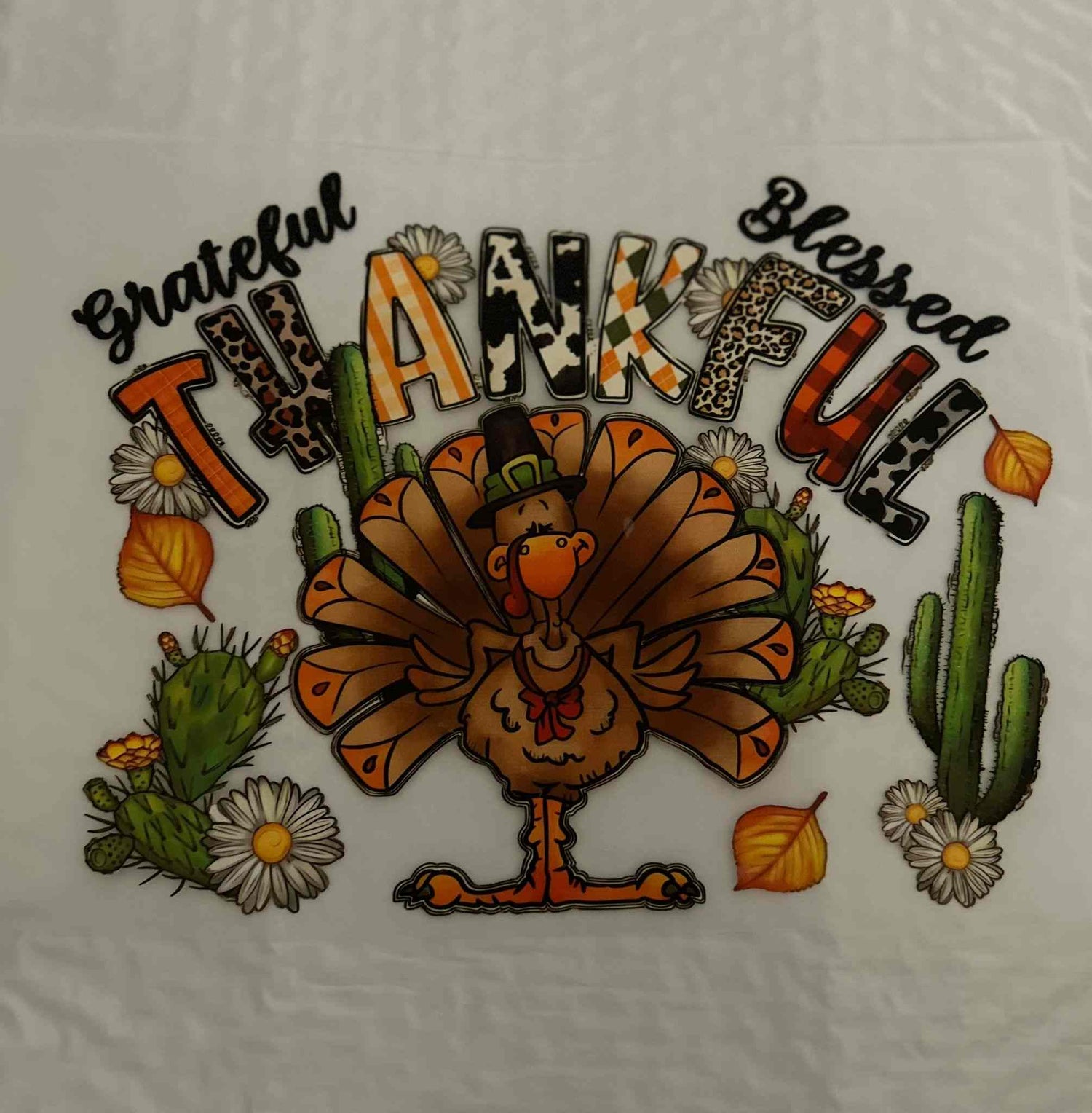 Colorful Thanksgiving turkey design with fall leaves, daisies, and cacti for holiday &amp; season decor.